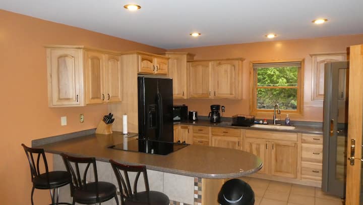 Kitchen cabinetry, island, and dining area